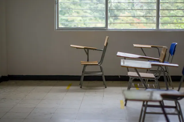 Sillas con pupitre vacías en un aula escolar