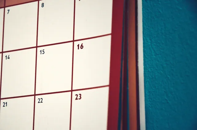 Primer plano de un calendario de pared junto a una pared azul
