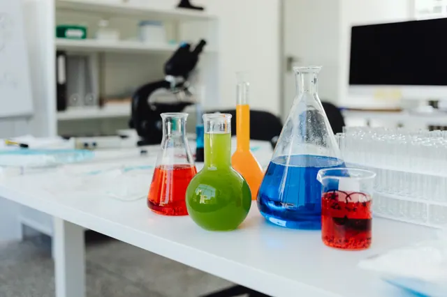 Matraces con líquidos de colores sobre una mesa de laboratorio