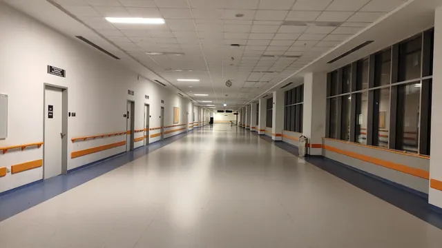 Pasillo vacío de un edificio hospitalario con puertas y ventanales