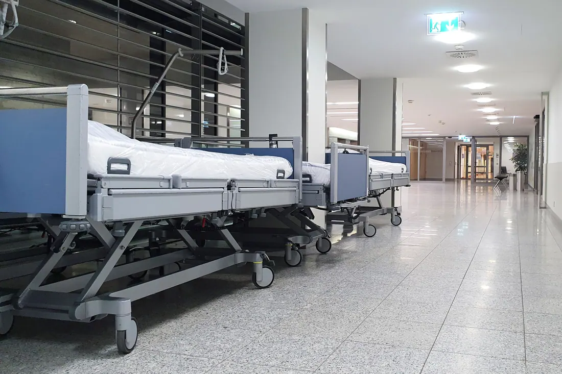Camas de hospital alineadas en un pasillo vacío