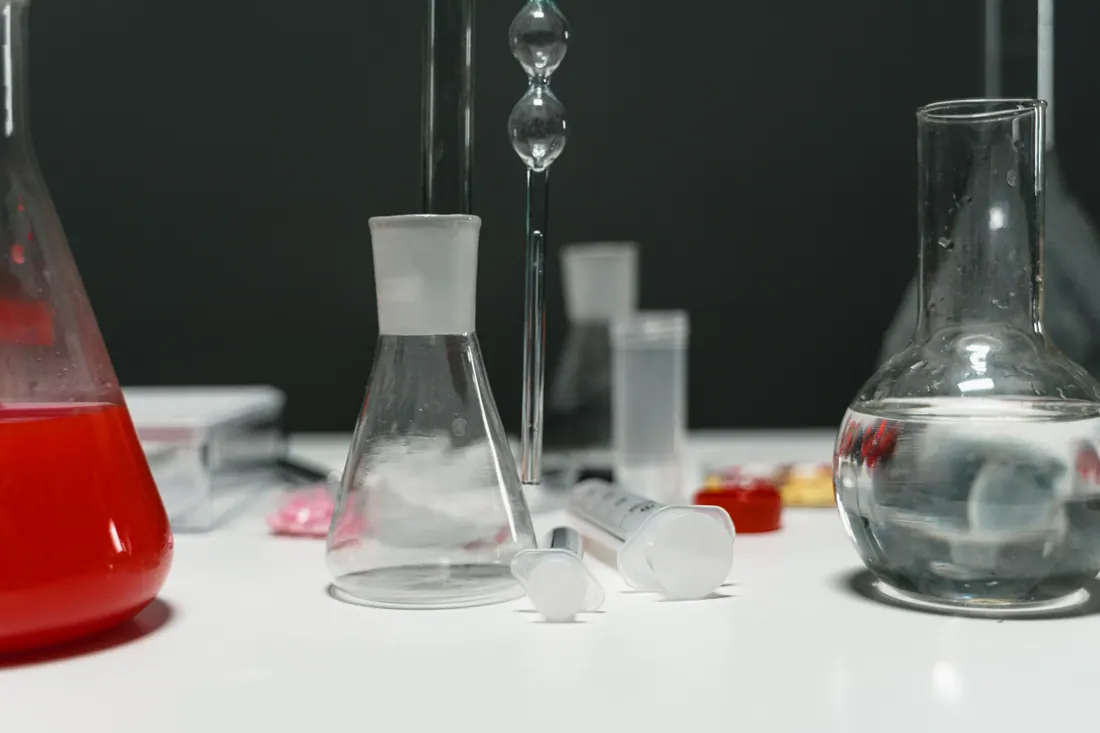 Material de laboratorio con matraces y líquidos sobre una mesa