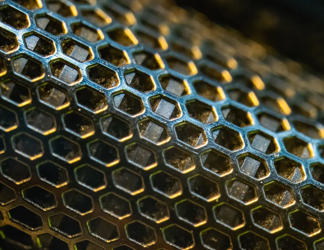 Primer plano de una rejilla metálica con patrón hexagonal