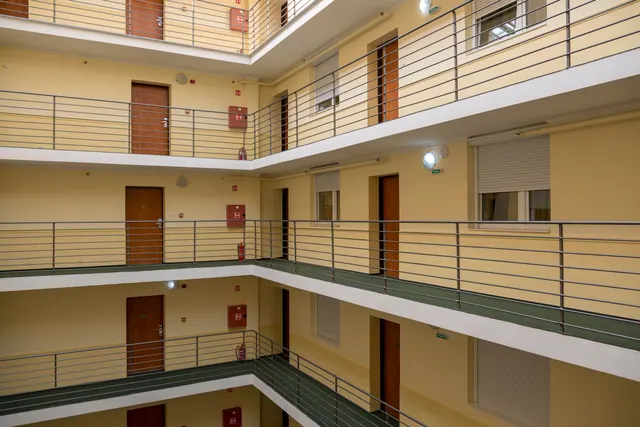 Interior de un edificio con varios pisos de pasillos y puertas