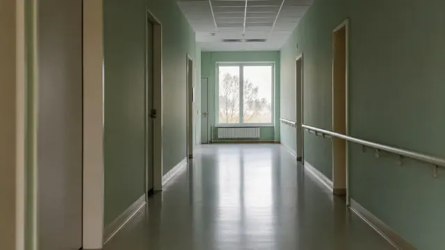 Pasillo de centro sanitario con paredes verdes y suelo de linóleo brillante