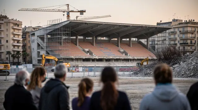 Grupo de personas observa obras de construcción en un estadio de fútbol