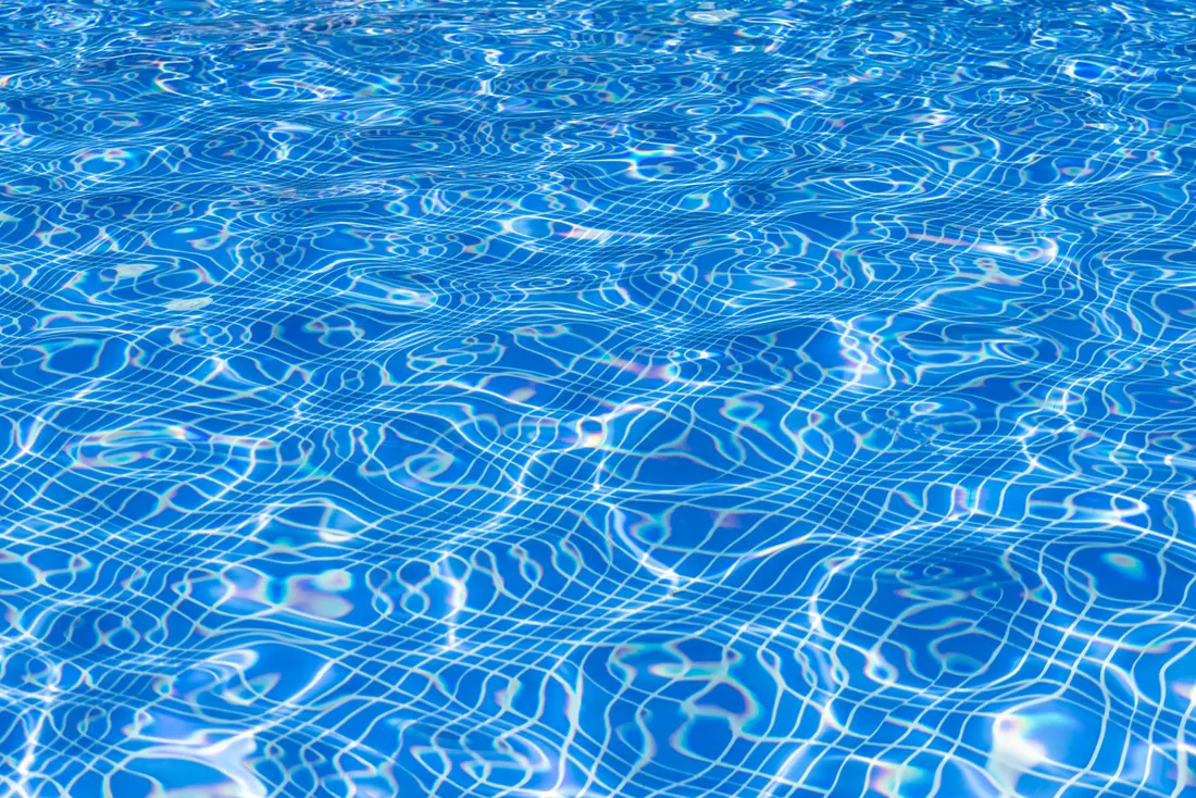 Superficie del agua de una piscina con reflejos de luz