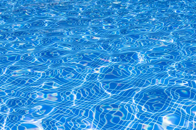 Superficie del agua de una piscina con reflejos de luz