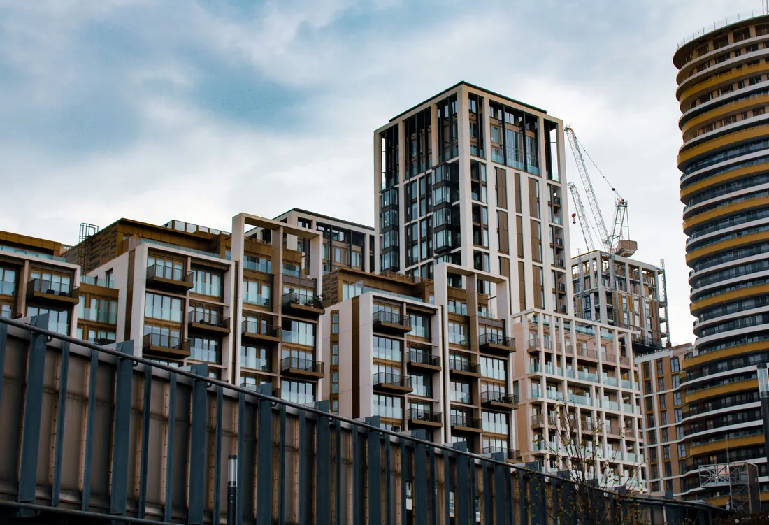 Conjunto de edificios residenciales modernos con una grúa de construcción