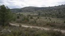 Paisaje de sierra mediterránea con vegetación dispersa y lecho de río seco en primer