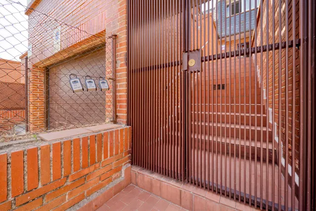 Verja metálica y escaleras en el patio trasero de una vivienda