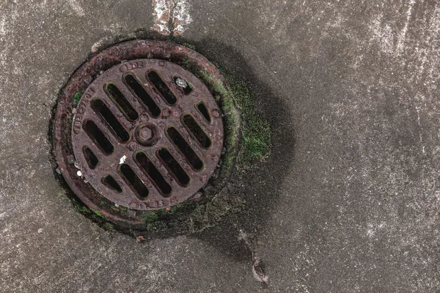Rejilla metálica oxidada de un desagüe en el suelo