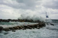 Olas rompiendo contra un espigón de rocas en el mar