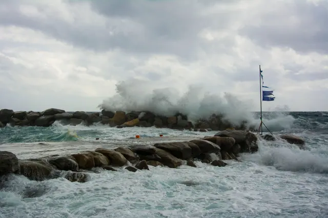 Olas rompiendo contra un espigón de rocas en el mar