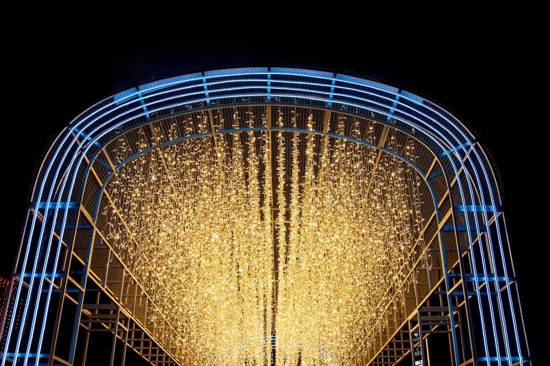 Túnel de luces navideñas iluminado por la noche