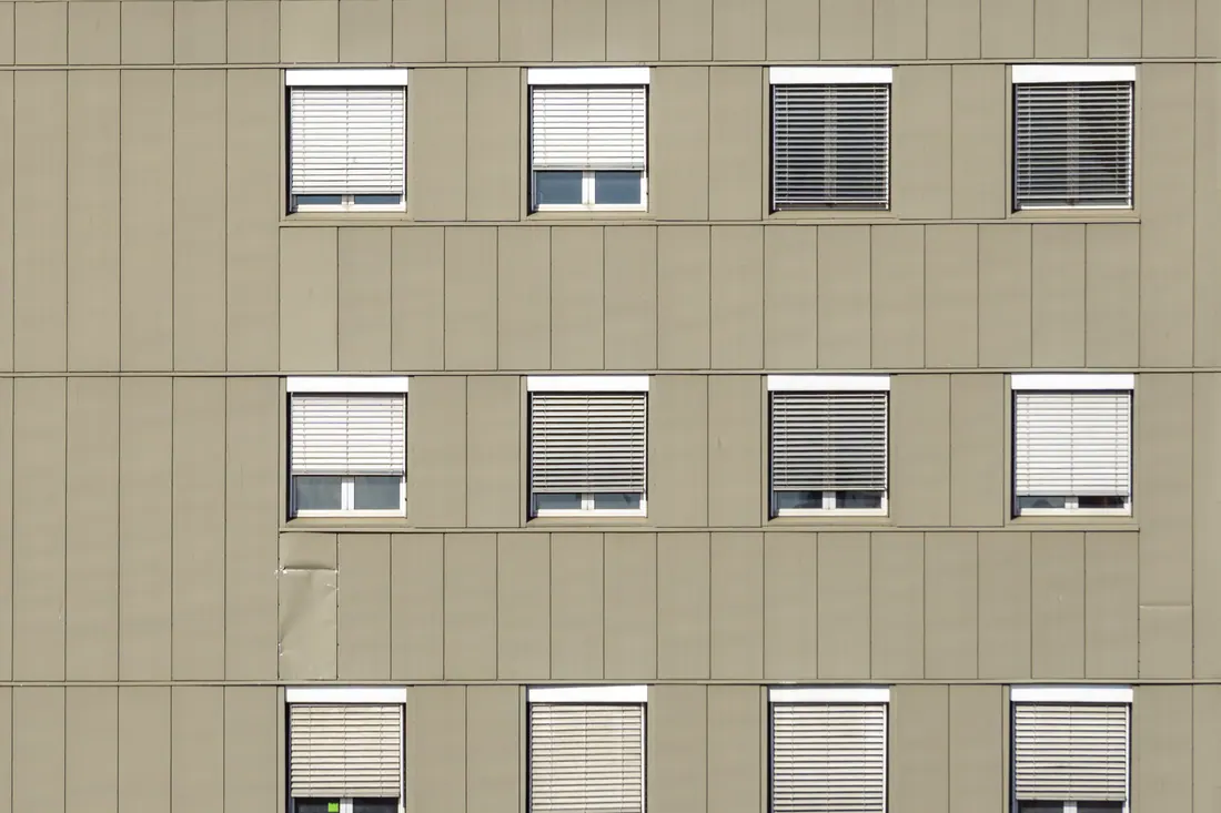 Fachada de un edificio con ventanas y persianas