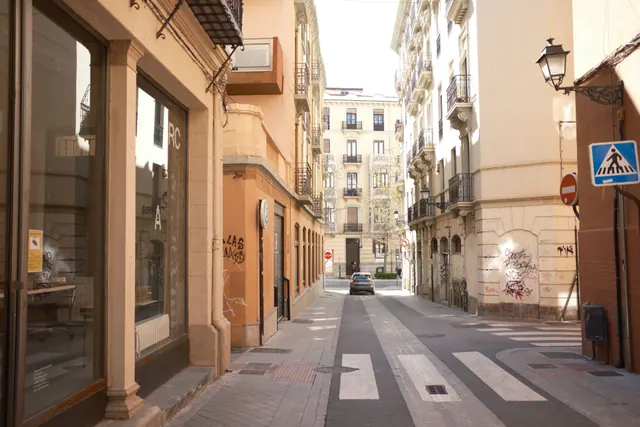Calle estrecha con edificios y un coche aparcado al fondo