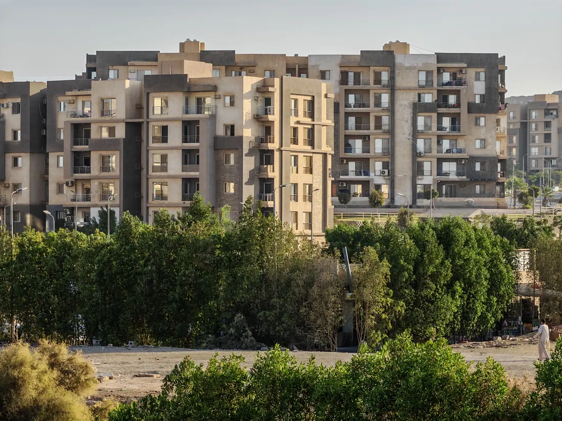 Solar sin urbanizar junto a bloques de viviendas en el borde de una ciudad