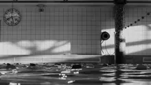 Piscina cubierta con un reloj de pared y una columna de mosaico