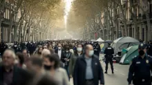 Multitud de personas en una avenida arbolada de una ciudad con carpas y presencia