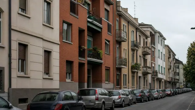Fila de vehículos aparcados frente a edificios residenciales de varios pisos