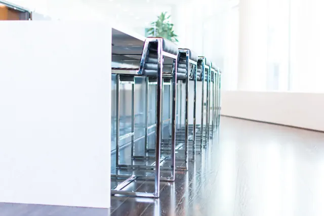 Fila de taburetes metálicos en un interior moderno