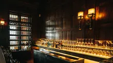 Barra de un bar con botellas y copas iluminadas