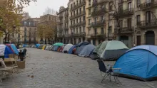 Campamento de tiendas de campaña en una plaza urbana rodeada de edificios