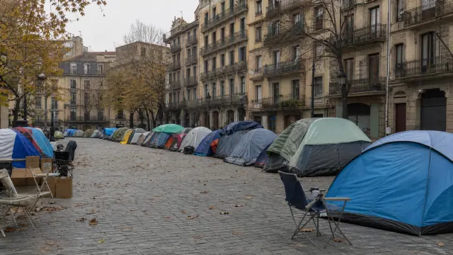 Campamento de tiendas de campaña en una plaza urbana rodeada de edificios