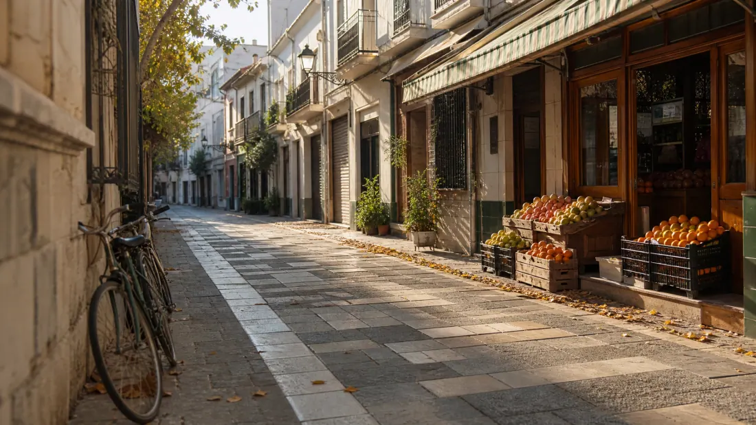 Calle empedrada de un barrio antiguo con edificios de piedra y una bicicleta aparcada