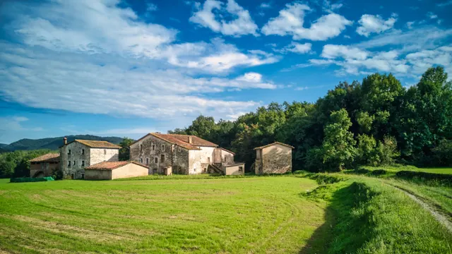 Masías de piedra rodeadas de campo y bosque