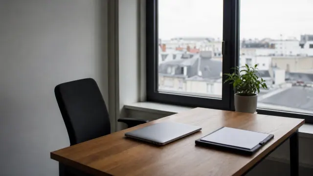 Escritorio de madera en una oficina con vistas a la ciudad desde grandes ventanales