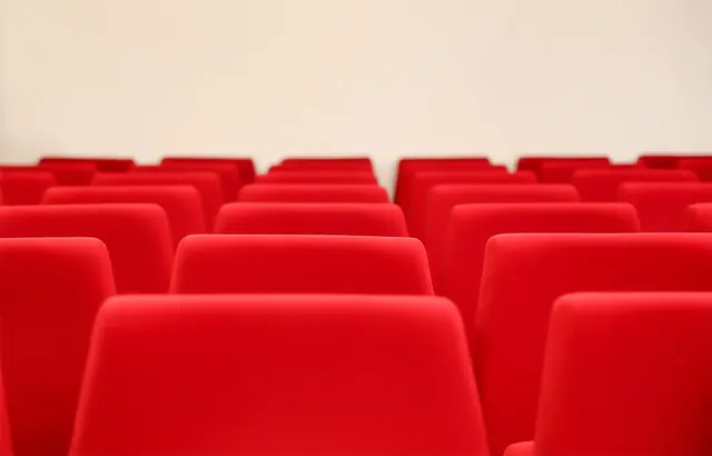 Filas de butacas rojas vacías en una sala de proyección o auditorio