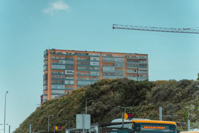Edificio de viviendas sobre una colina con una grúa de construcción