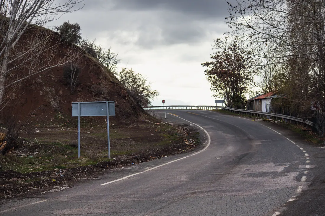 Curva de una carretera secundaria junto a un talud de tierra