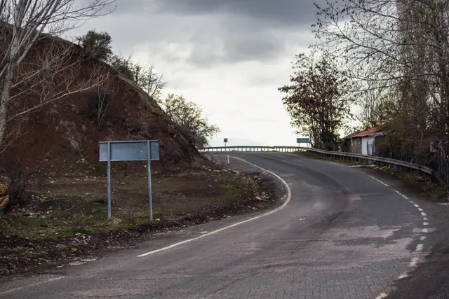 Curva de una carretera secundaria junto a un talud de tierra