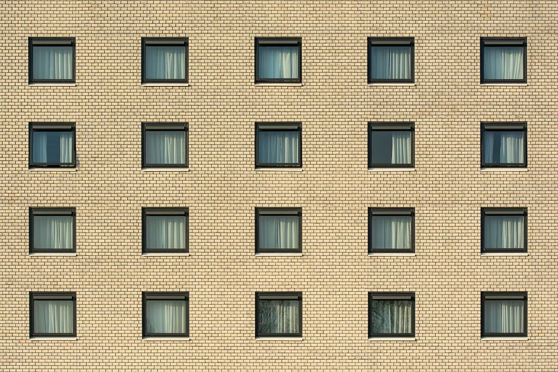 Fachada de un edificio de ladrillo con ventanas alineadas en filas