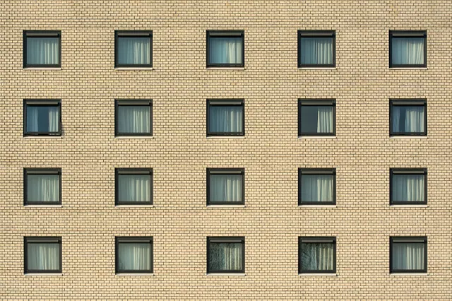 Fachada de un edificio de ladrillo con ventanas alineadas en filas