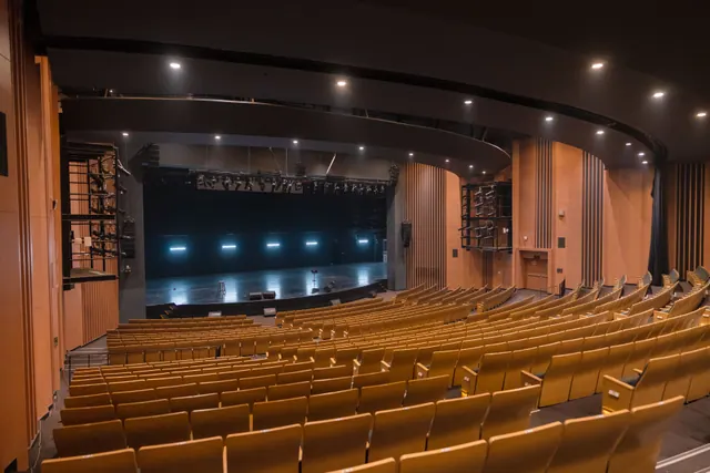 Interior vacío de un teatro con butacas y escenario