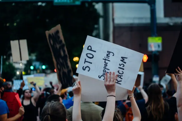 Concentración antirracista con pancartas en una plaza urbana