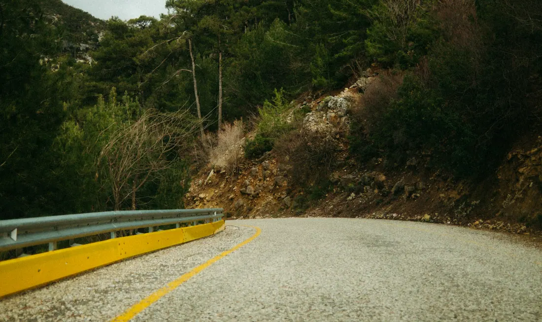 Carretera de montaña con curva y quitamiedos amarillo
