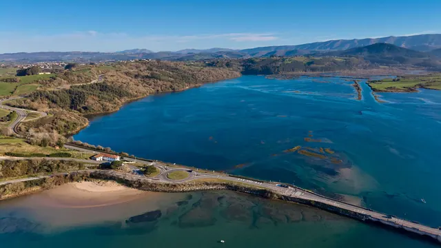 Vista de una ría con villas y prados verdes en la costa del norte peninsular