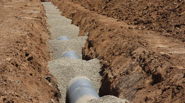Zanja con tuberías y grava para una obra de canalización