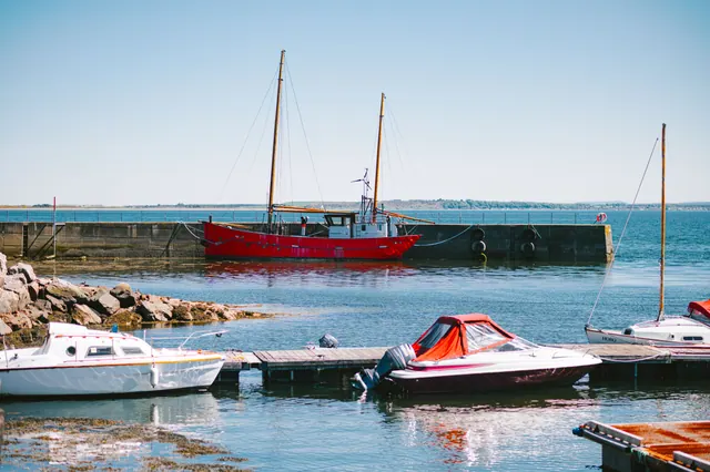 Barcos amarrados en un puerto junto a un rompeolas