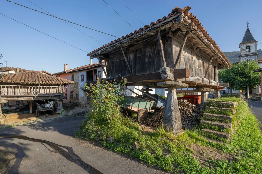 Hórreo tradicional de madera sobre pegollos de piedra en un entorno rural