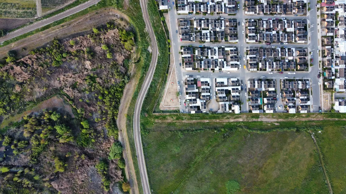 Vista aérea de una urbanización junto a terrenos y campos