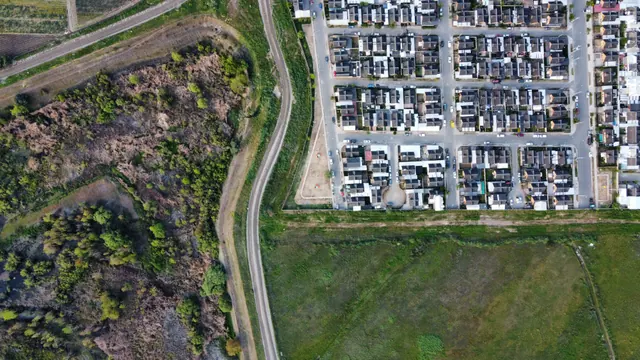 Vista aérea de una urbanización junto a terrenos y campos