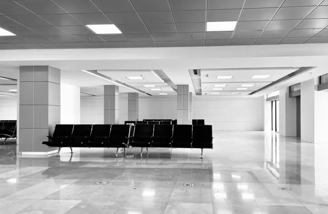 Sala de espera vacía con asientos metálicos en un edificio público