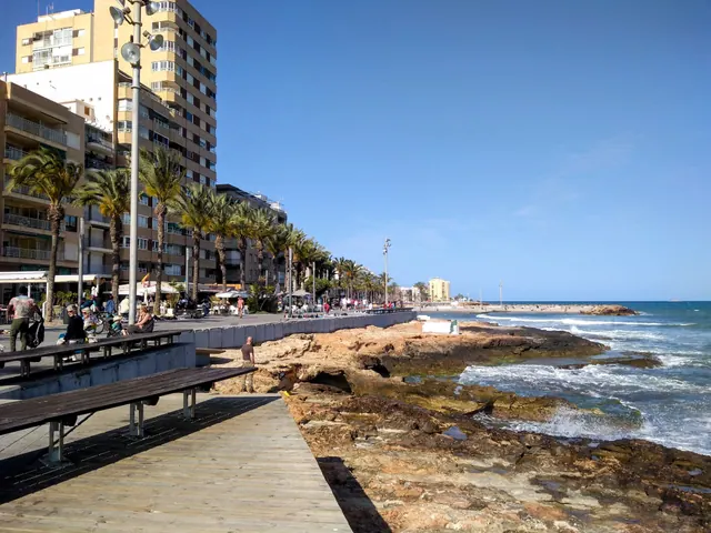 Paseo marítimo junto a rocas y edificios frente al mar