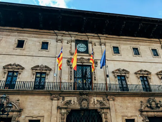 Fachada de un edificio histórico con balcón y banderas